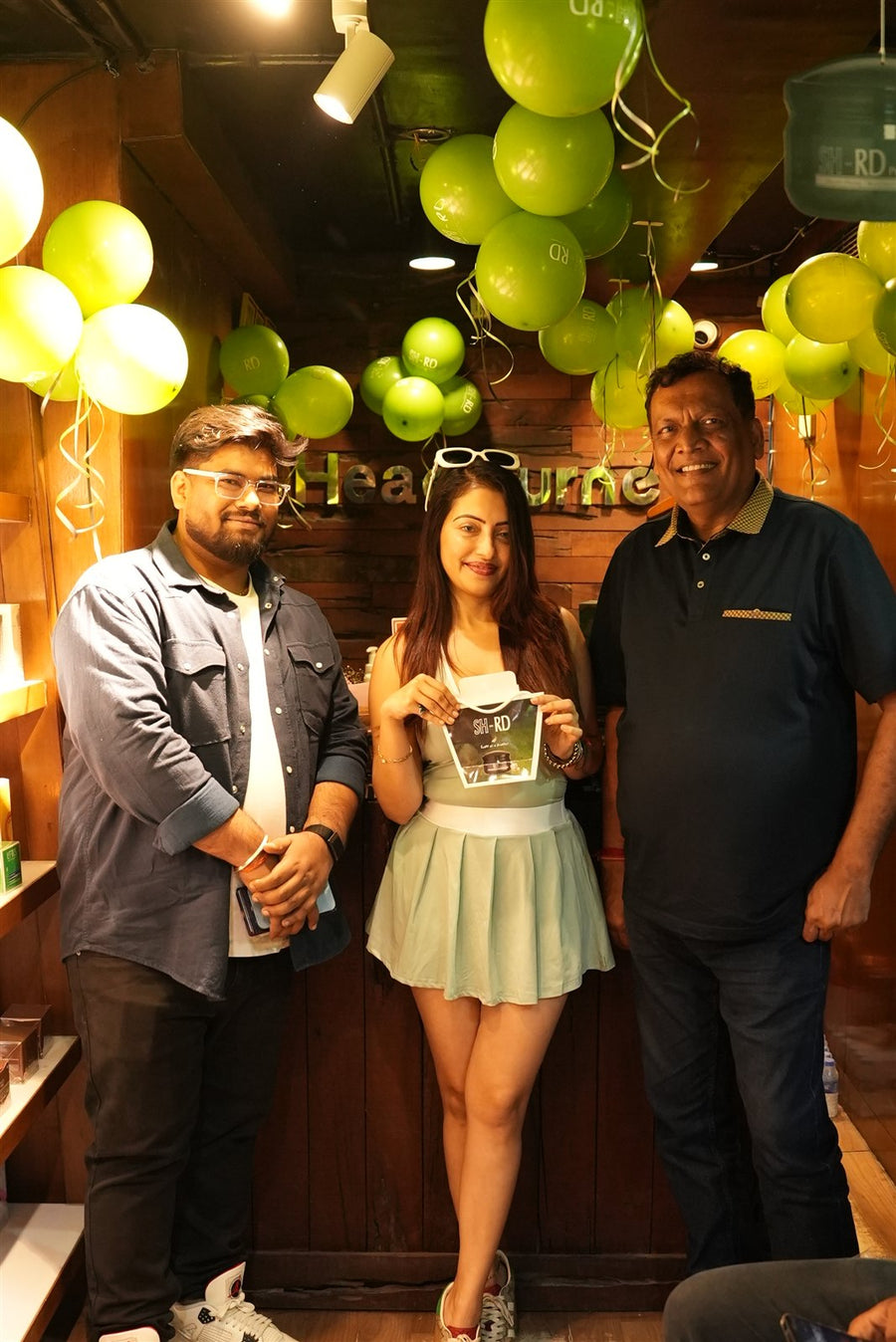 Guests and the Pure Scalp team celebrating with green balloons at Avani Riverside Mall